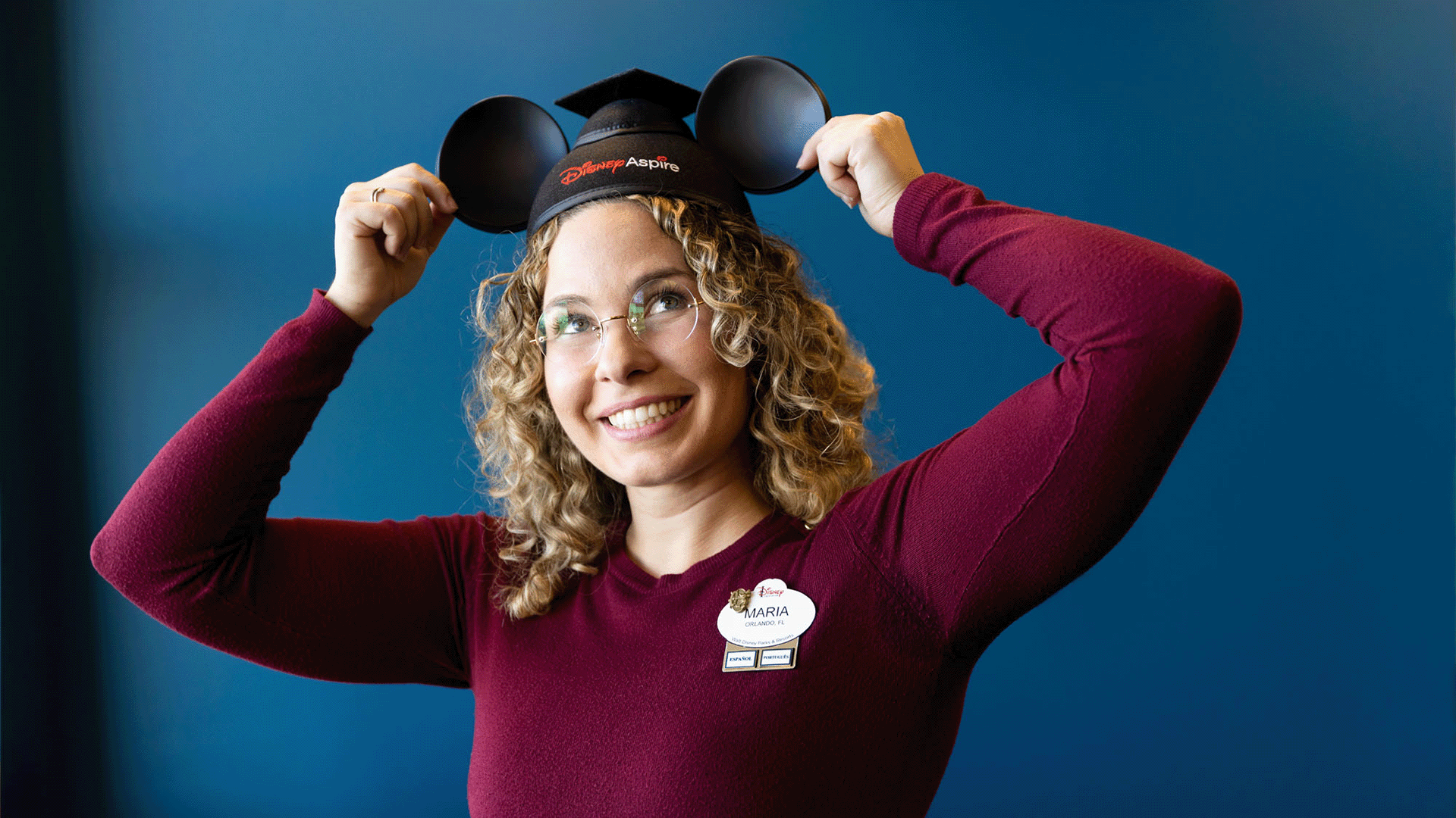 Disney Aspire graduate Maria with a Mickey Graduate Hat on