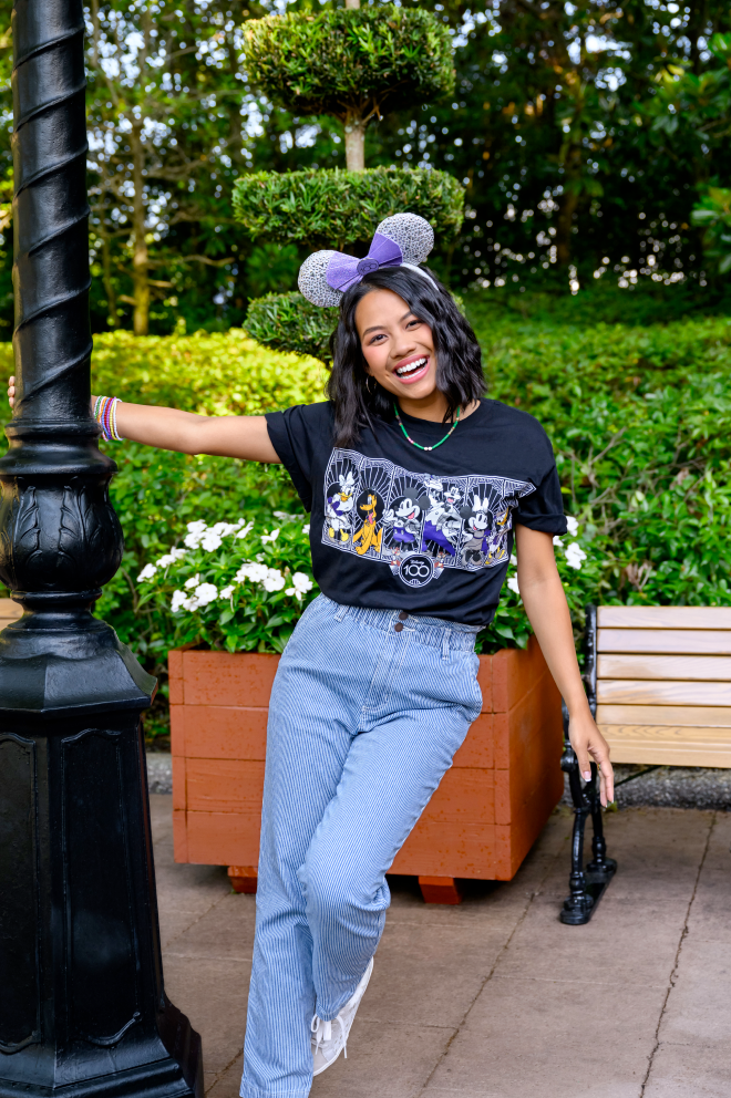 Girl smiling wearing Disney100 mickey ears and t shirt