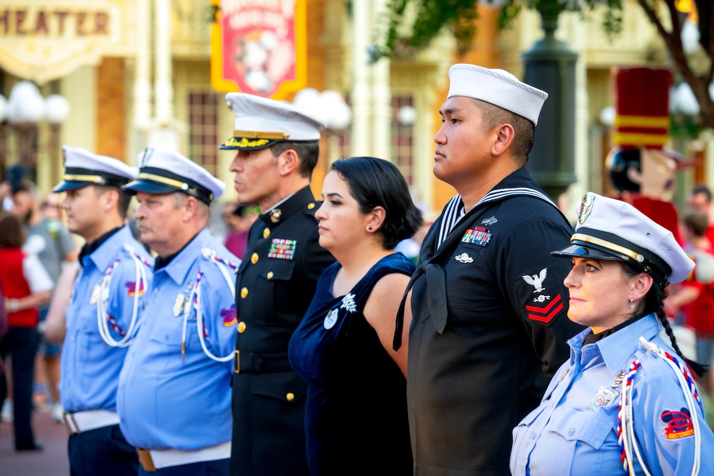 Uniformed service members lined up during a ceremony at a Disney park.