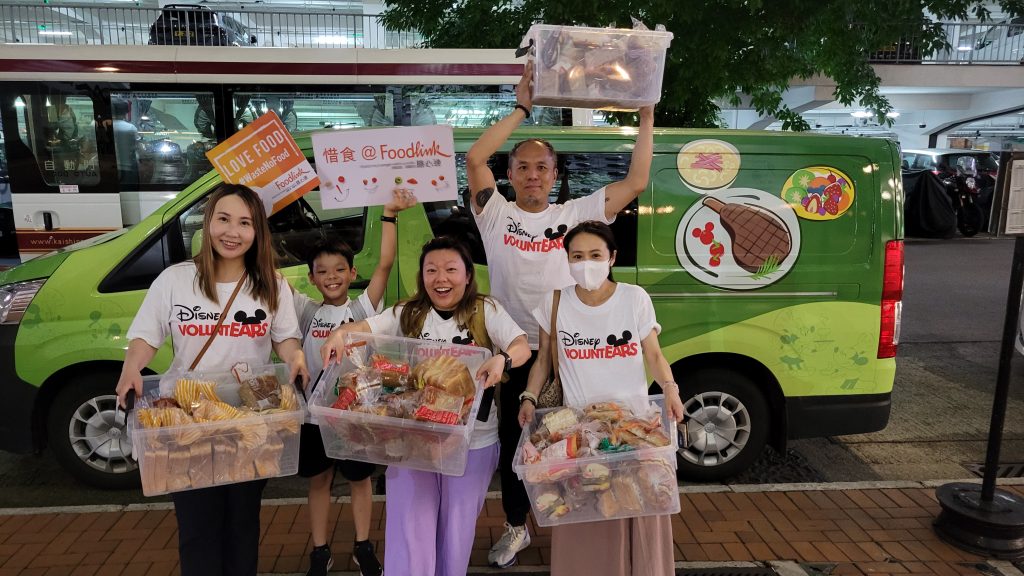 VoluntEARS from Hong Kong Disney carry boxes of surplus bread to donate