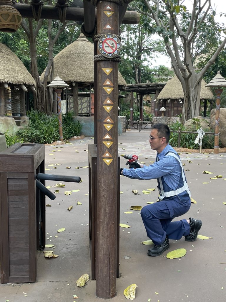 Hong Kong Disney cast member using drill on wooden beam