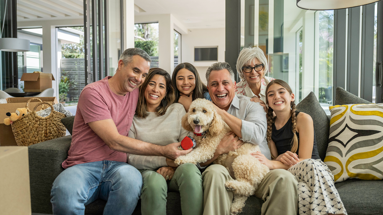 Family smiling on couch in a new home