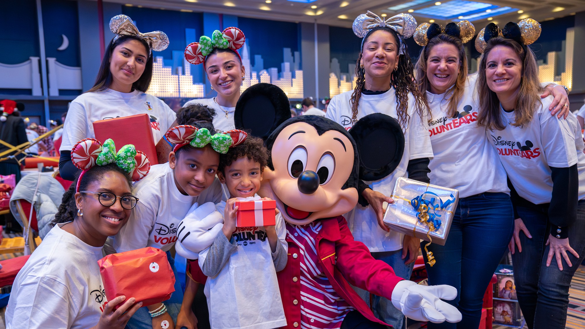 Disney VoluntEARs standing with Mickey Mouse at a gift giving event