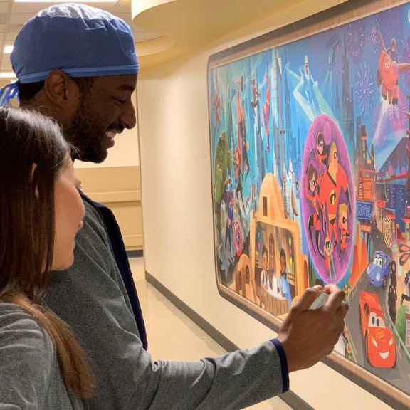 Hospital staff view a character mural created as part of Disney’s $100 million commitment to support children’s hospitals around the world