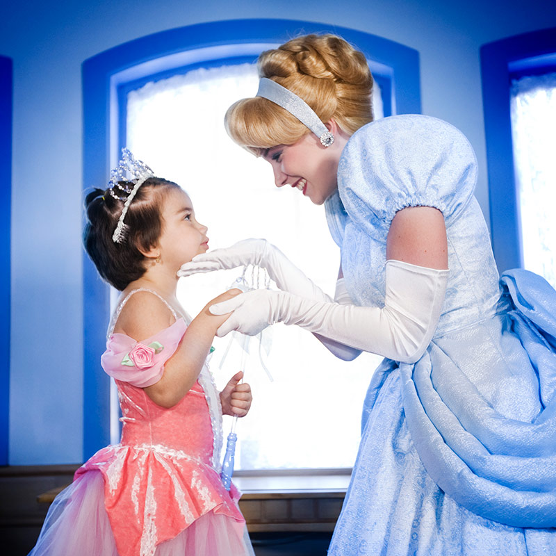 Cinderella greets a child dressed as a princess who is visiting Walt Disney World Resort for a wish trip.