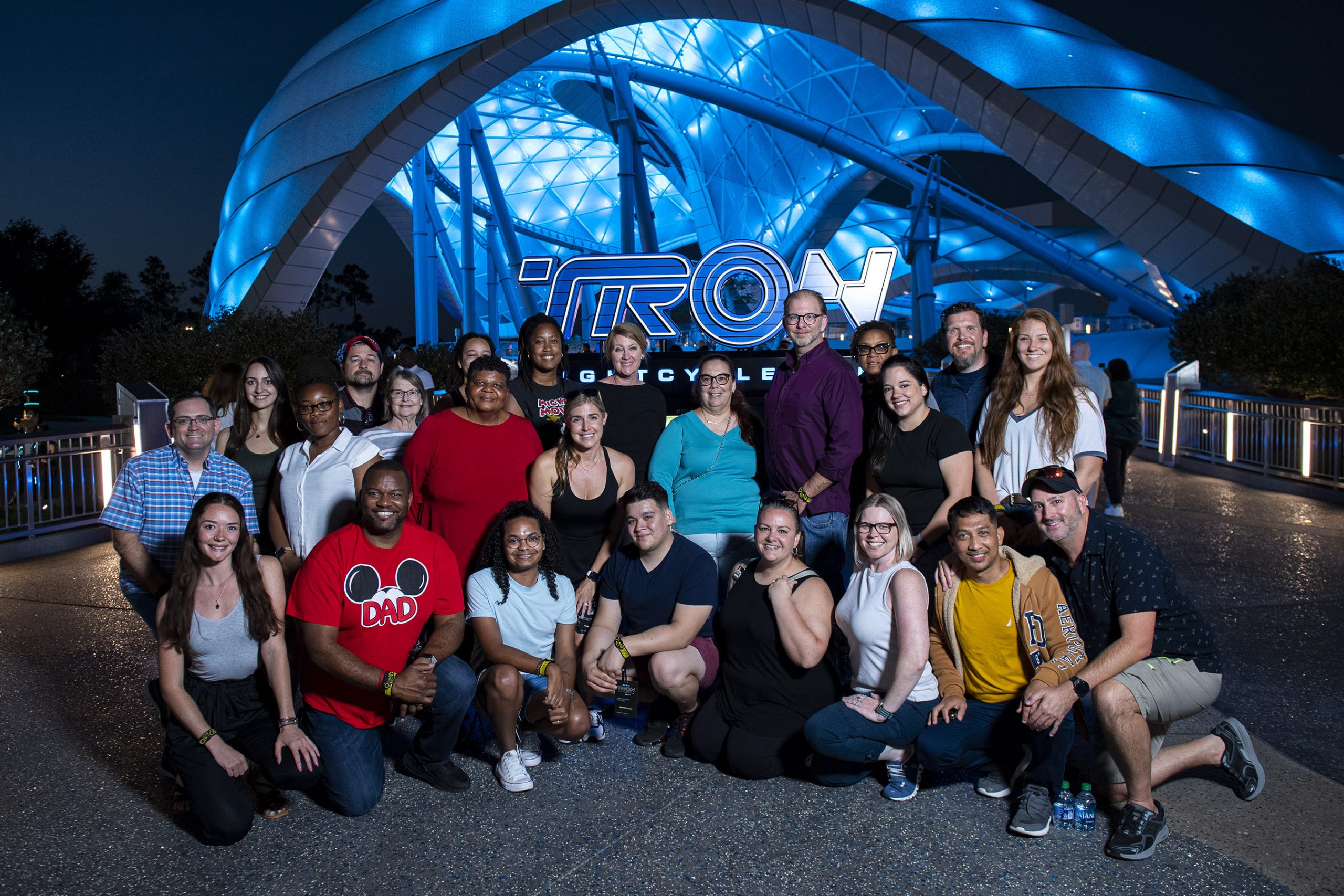Group of community members standing in front of the TRON: Lightcycle / Run marquee in Magic Kingdom
