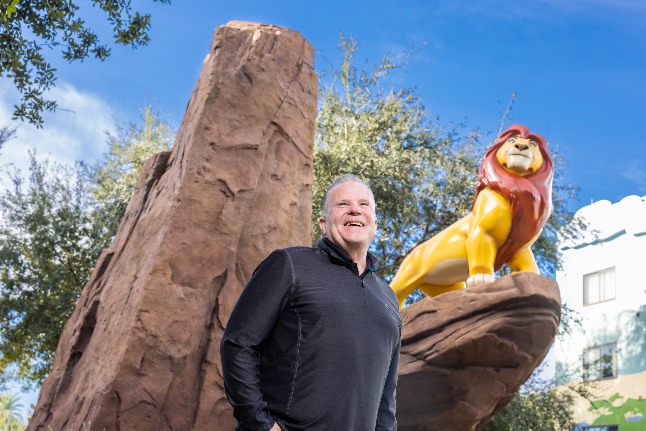 President of Intex Coating, James Delahanty stands by the Simba statue at Disney’s Art of Animation Resort