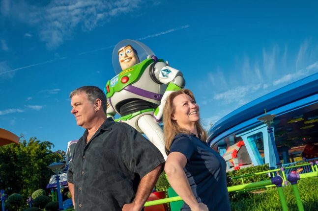 Woman and man standing by giant Buzz Lightyear statue