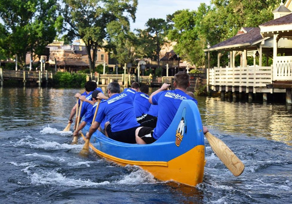 People rowing a canoe in water at Magic Kingdom Park.