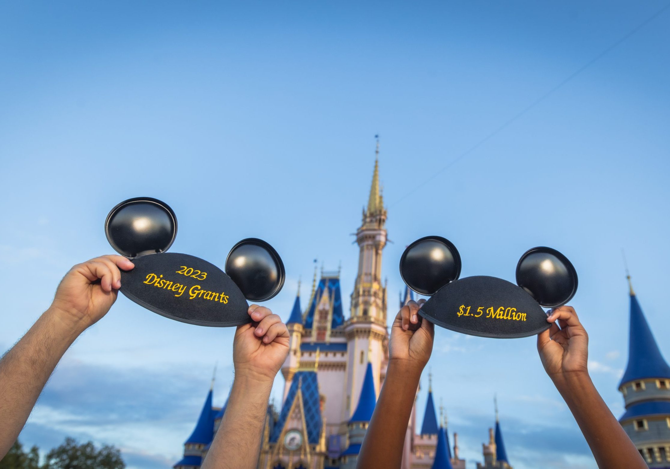 Two Mickey ear hats in front of Cinderella Castle with the embroidery saying "2023 Disney Grants" and "$1.5 million".