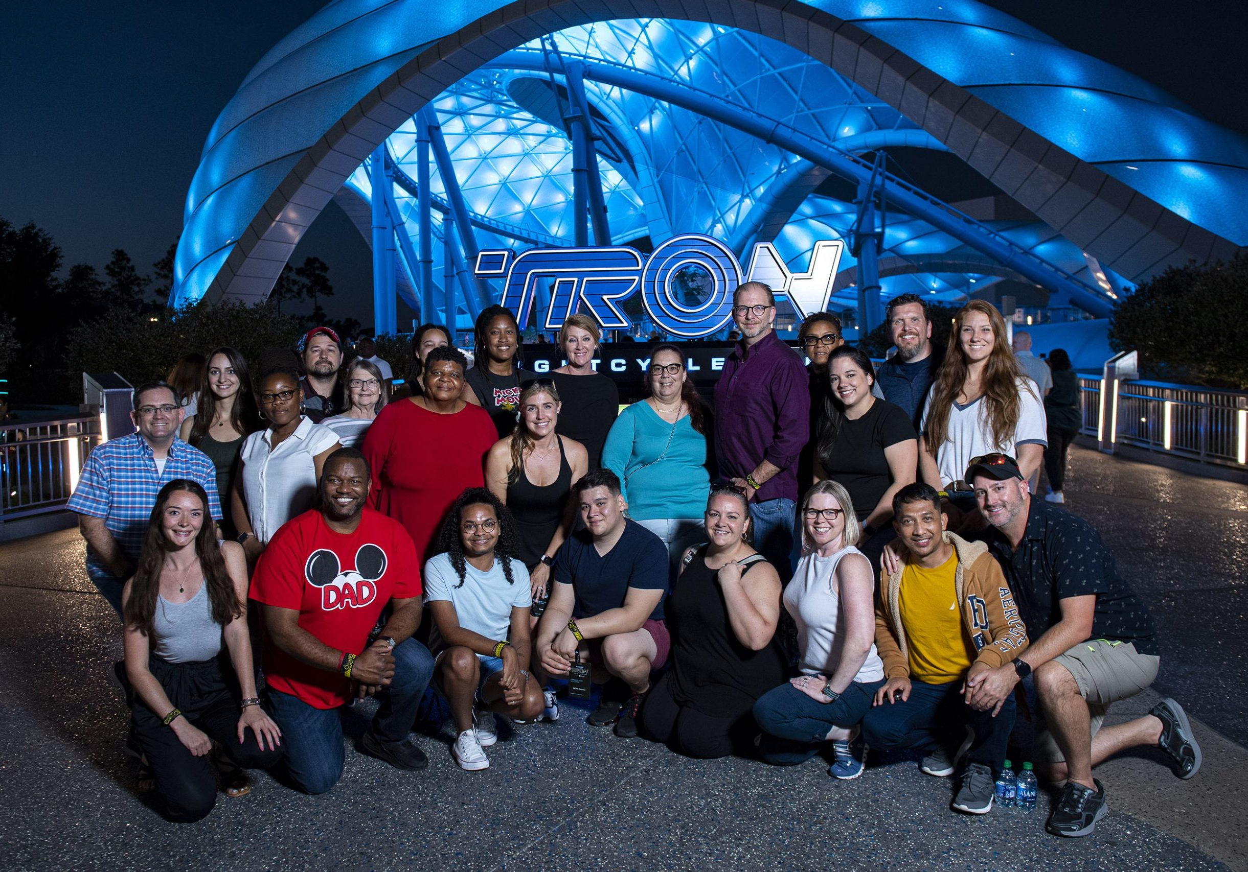 Group of community members standing in front of the TRON: Lightcycle / Run marquee in Magic Kingdom