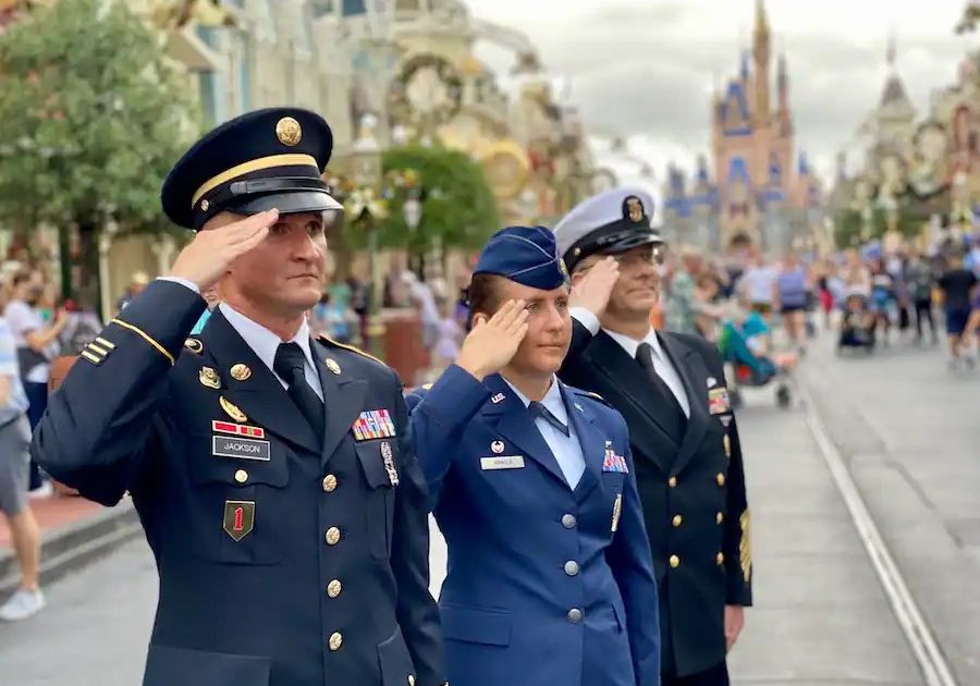 Transforming Communities Service men and women saluting on Main Street U.S.A. at Disney’s Magic Kingdom Park.