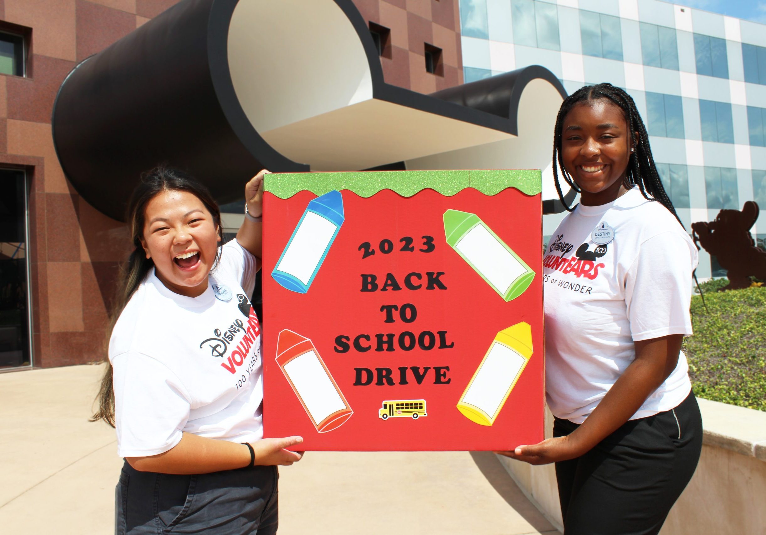 volunteers holding a back to school sign