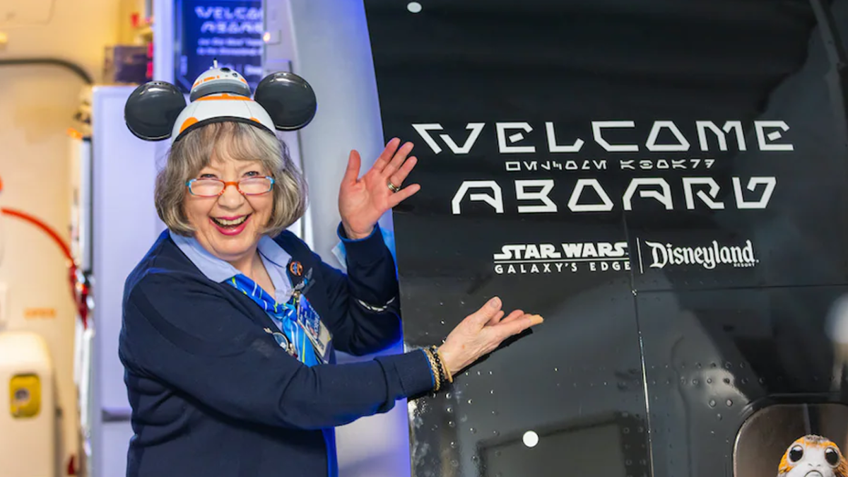 Flight attendant in BB8 ears shows off the "Welcome Aboard" message on the outside of the airplane.