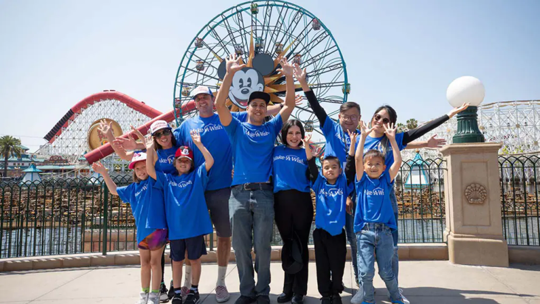 Families wearing blue Make a Wish shirts at Pixar Pier.
