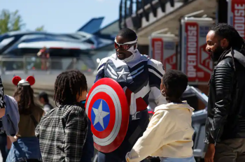 The new Captain America greets two boys and their dad at Avengers Campus in Disneyland Paris.