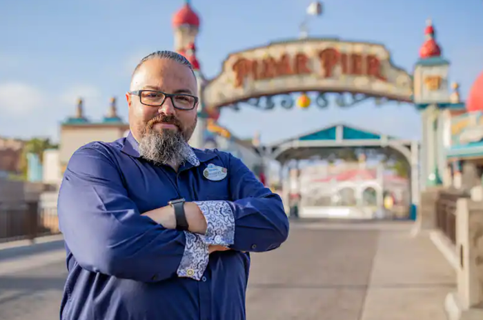Robert standing with his arms crossed in front of Pixar Pier.