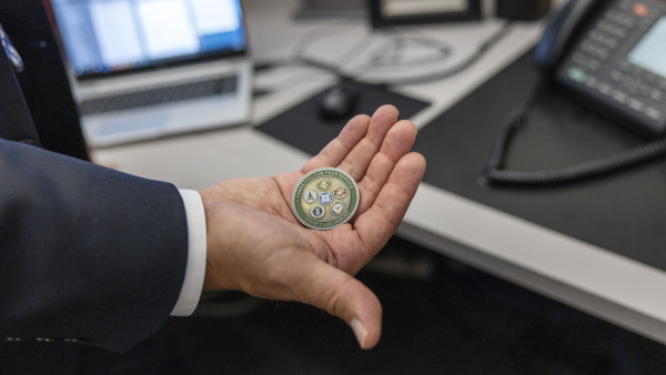 Ariel holding a Disneyland Veteran coin.