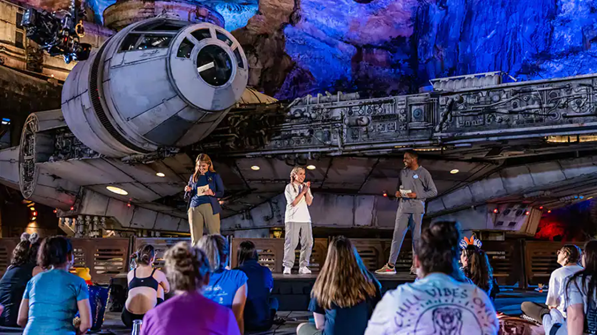 Walt Disney World Ambassadors Ali and Reavon with Ashley onstage in front of the Millennium Falcon.