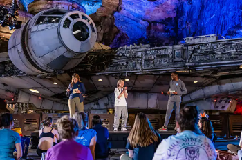 Walt Disney World Ambassadors Ali and Reavon with Ashley onstage in front of the Millennium Falcon.