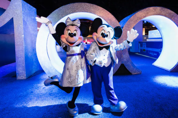 Mickey and Minnie pose with 100 numbers.