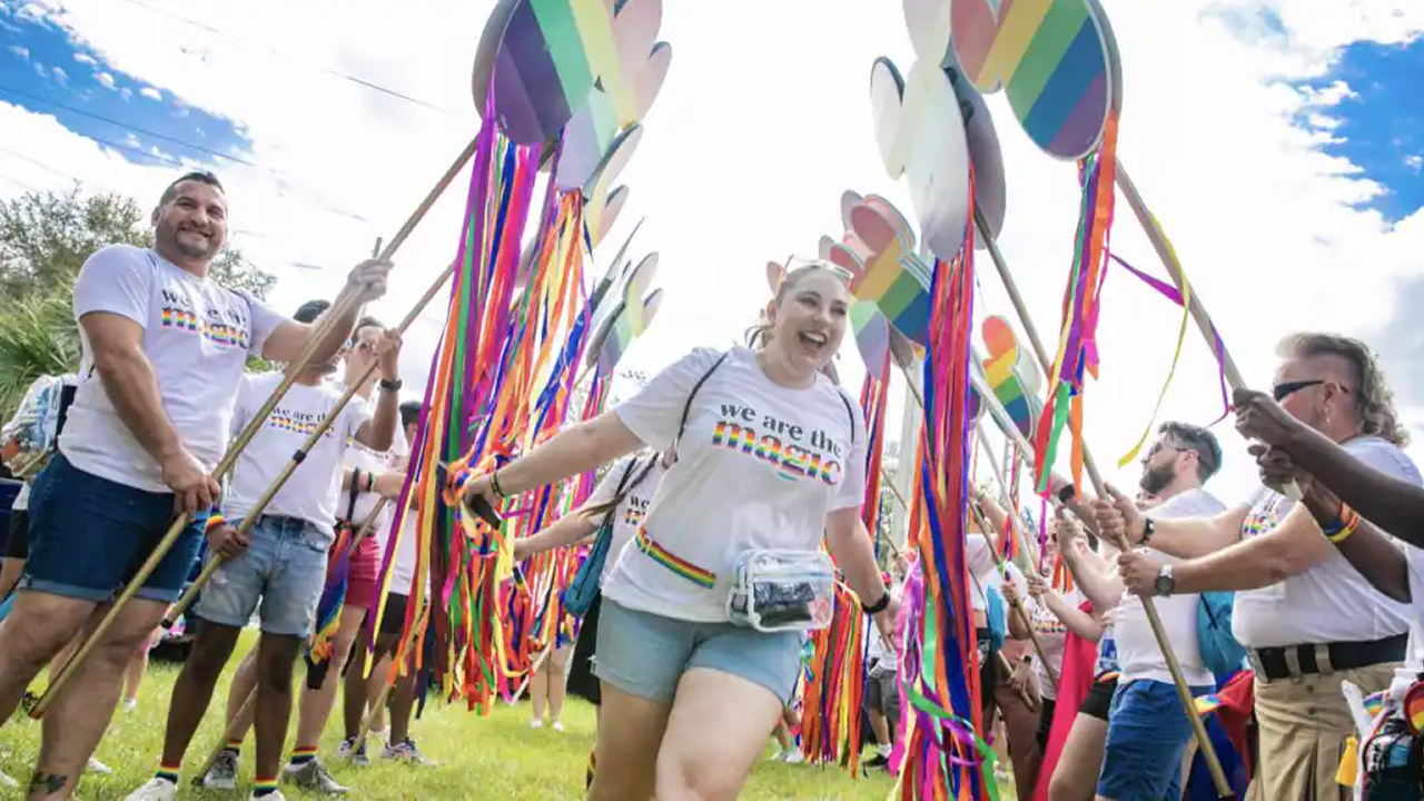 Woman running through Mickey Pride flags. 