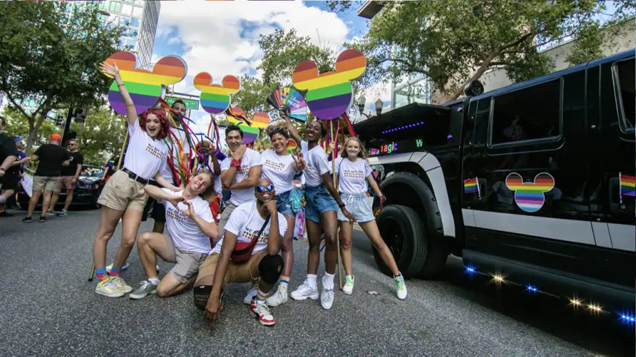 Group posed for a photo in the Pride parade next tot he Disney DJ vehicle. 