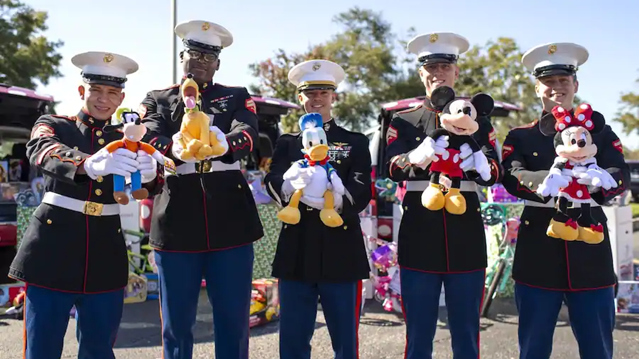 Marines holding Disney plush.