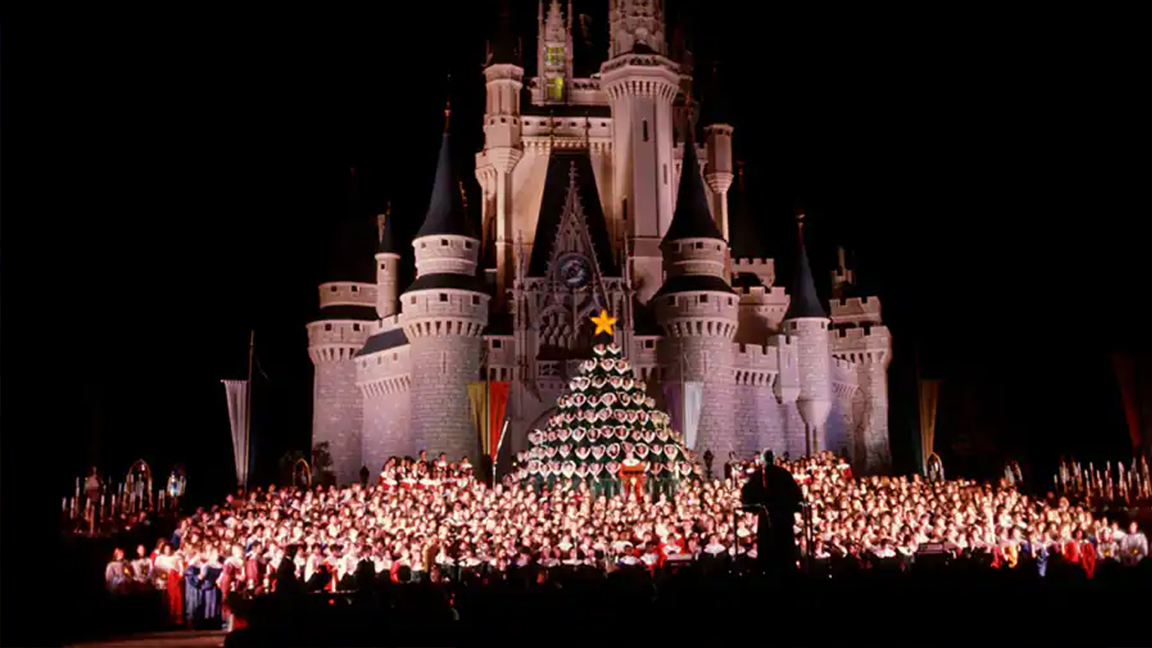 Historical photo of one of the first Candlelight Processionals to be held at Walt Disney World in front of Cinderella Castle. 