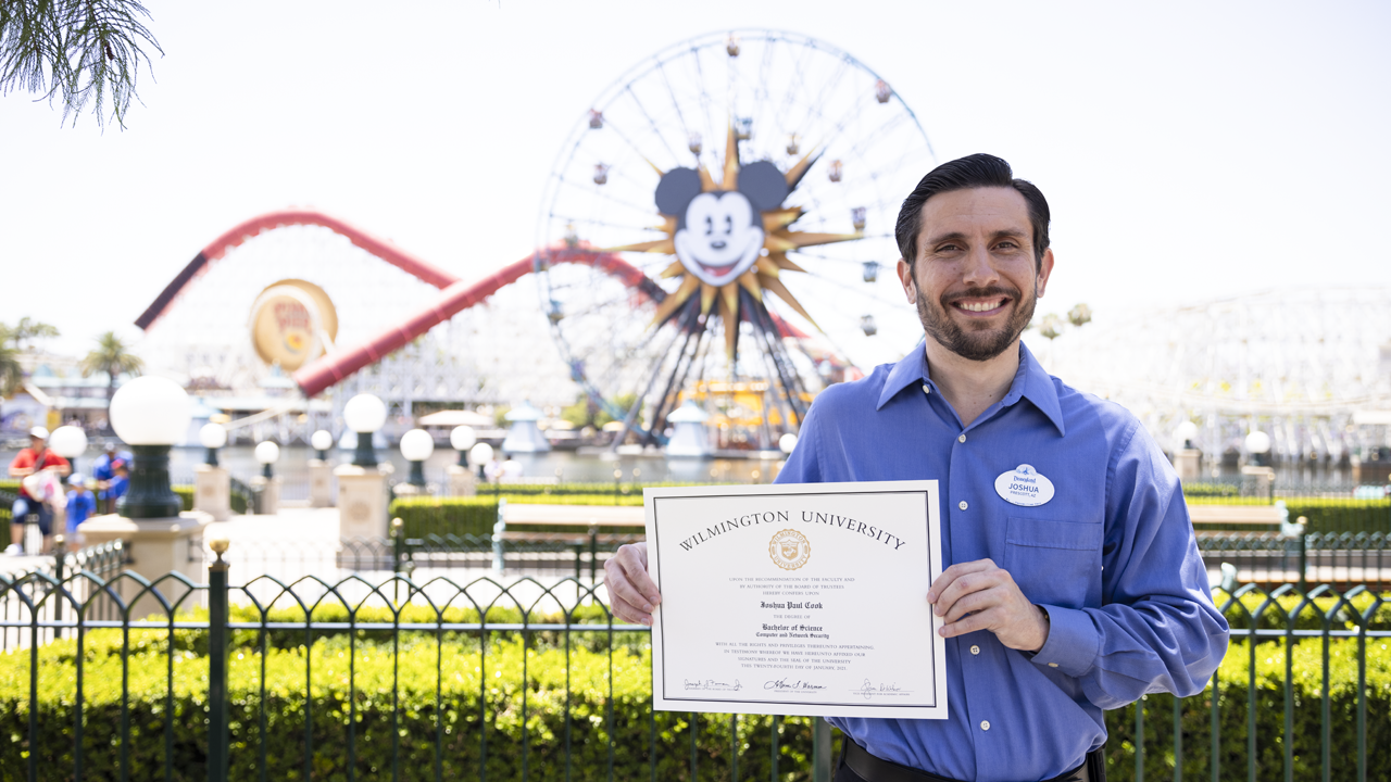 Joshua holding up his diploma. 