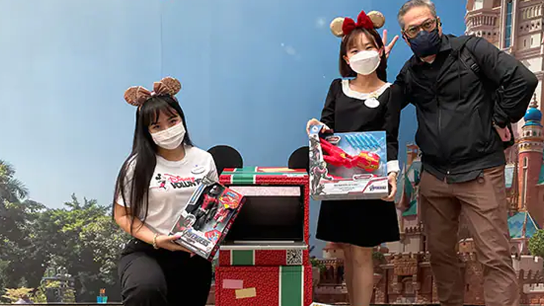 Three Cast Members pose with toys being donated.