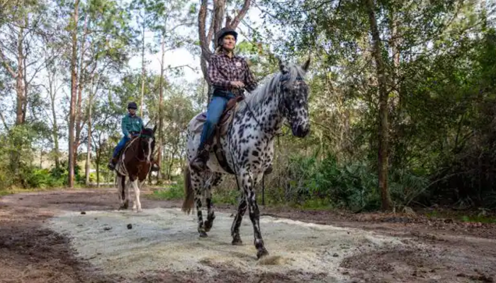 Women riding a horse at Fort Wilderness Resort and Campground.