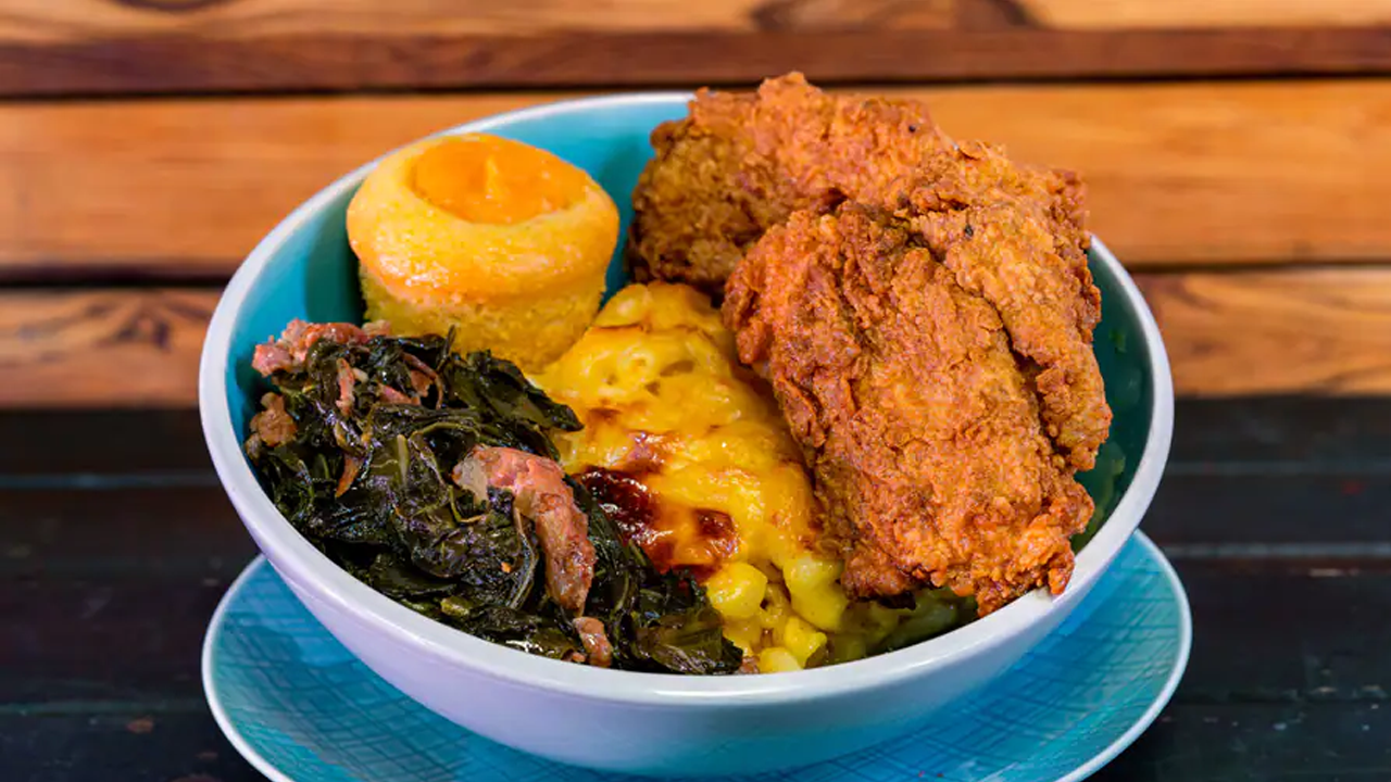Bowl of fried chicken, collard greens, macaroni and cheese, and cornbread. 