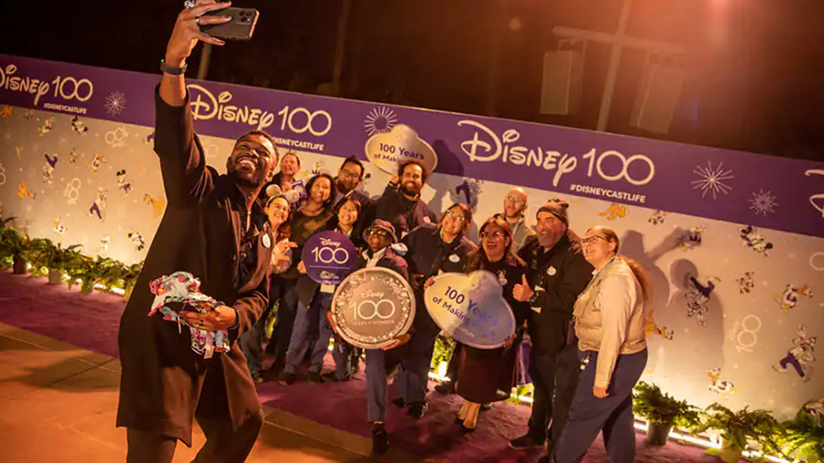 The Disneyland Resort Ambassador taking a selfie with Cast Members at the Disney 100 Celebration.
