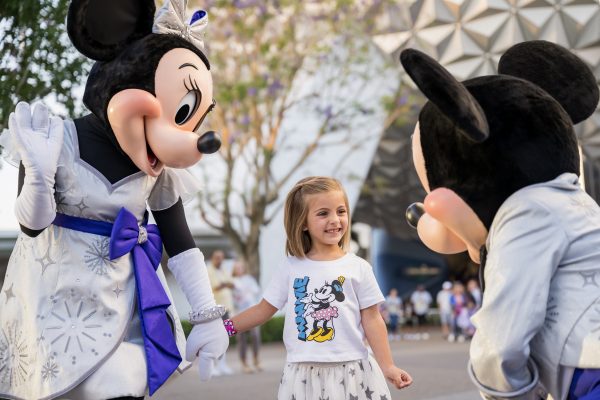 A little girl meeting Mickey and Minnie in person.