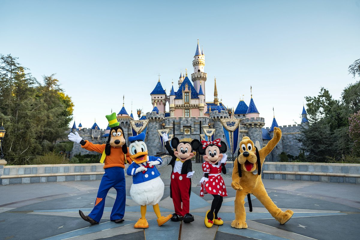 Goofy, Donald, Mickey, and Pluto in front of Sleeping Beauty Castle at Disneyland