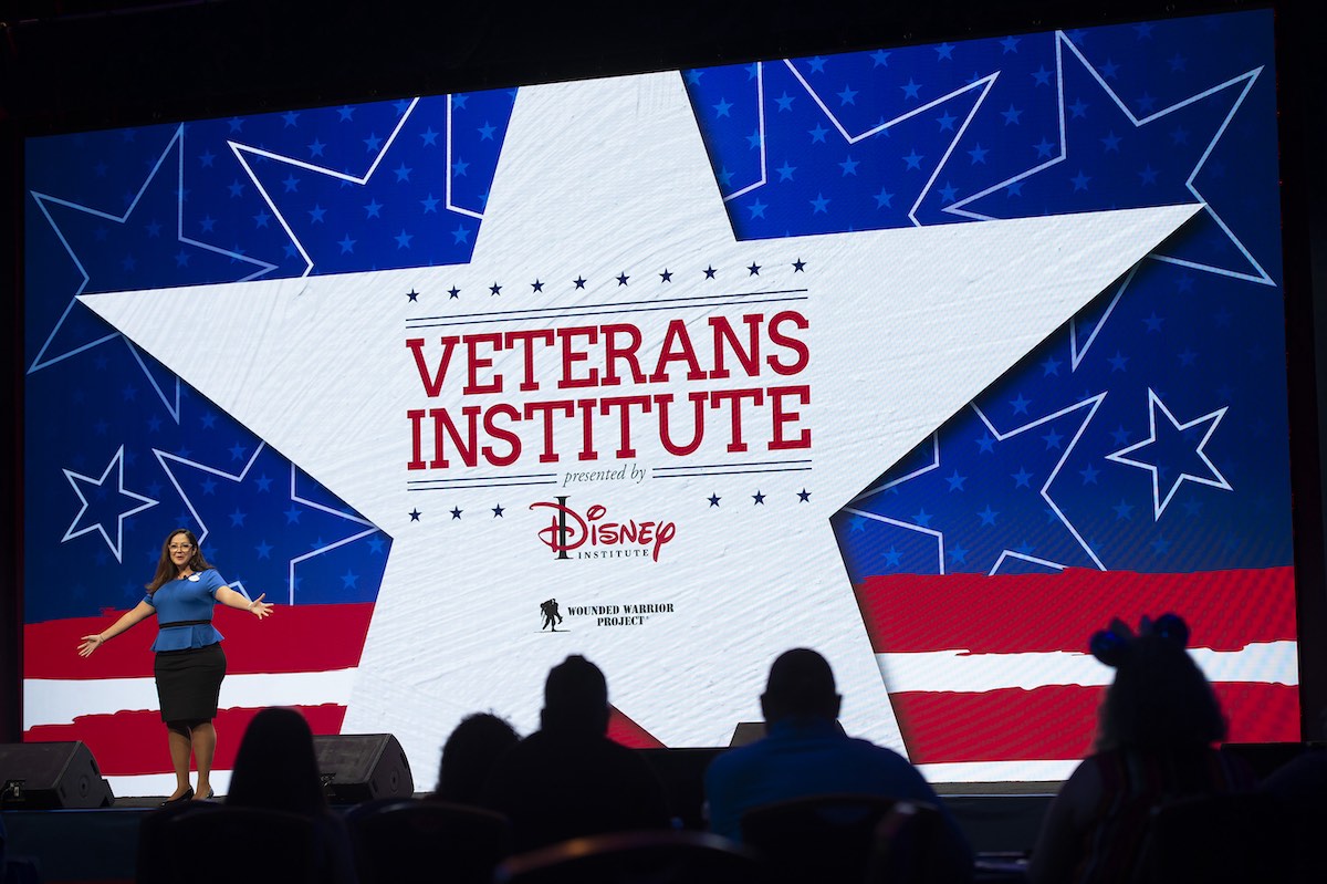 A woman speaks from the stage at the Veterans Institute, presented by Disney