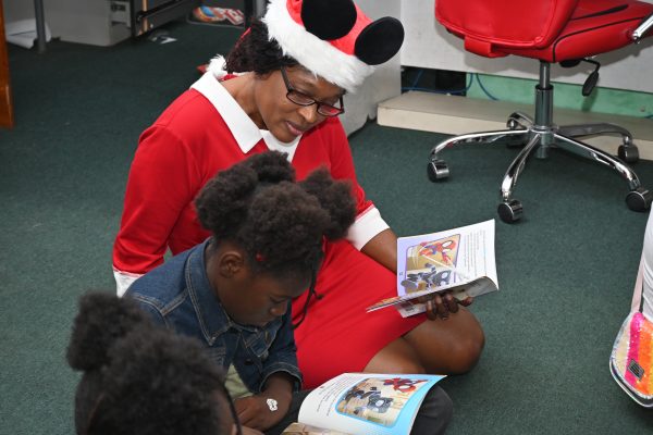 Crew member volunteers by reading book to a child