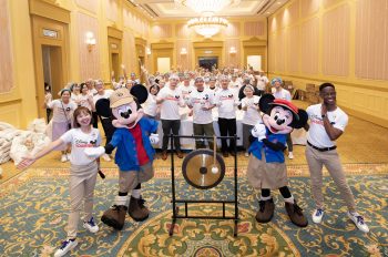 cast members at hong kong disney pose with Mickey and Minnie Mouse after a day of giving