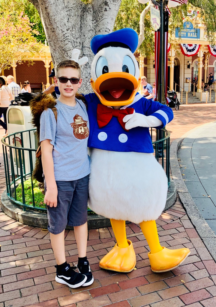 Jennifer’s son posing with Donald Duck at Disneyland park