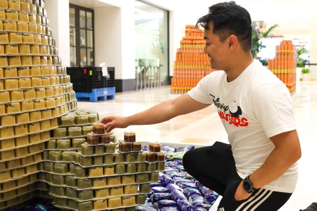 Disney VoluntEAR Charlie Manalo helps build a can structure of Louis from The Princess and the Frog.