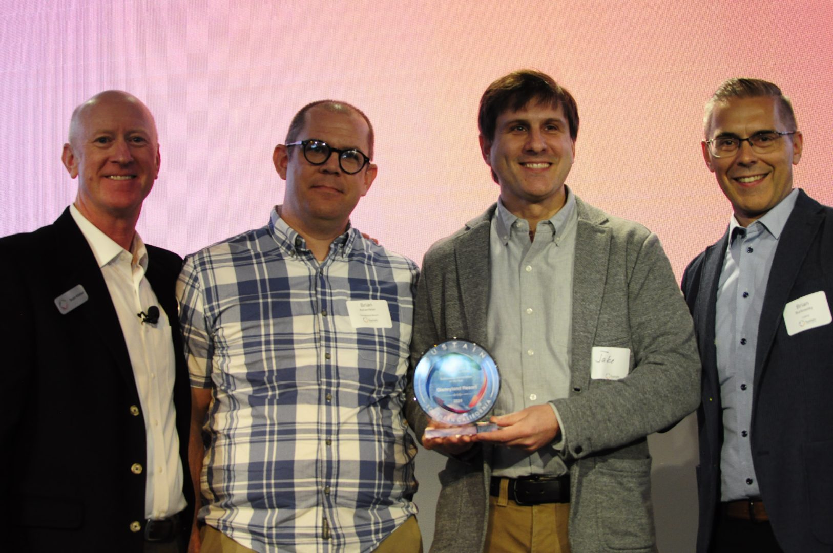 Disneyland Resort Environmental Integration cast members (center) Brian Ashenfelter and Jake Raykhelson accept the Sustainable Corporation of the Year award.