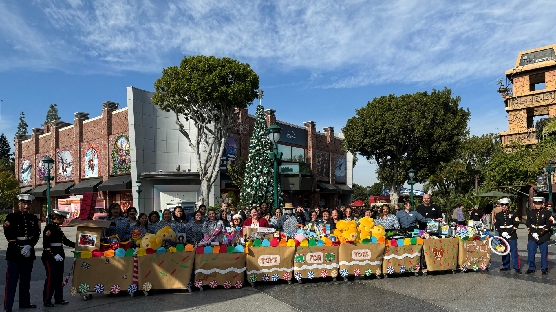 Cast come together with U.S. Marines to capture a photo of their donation in Downtown Disney District. 