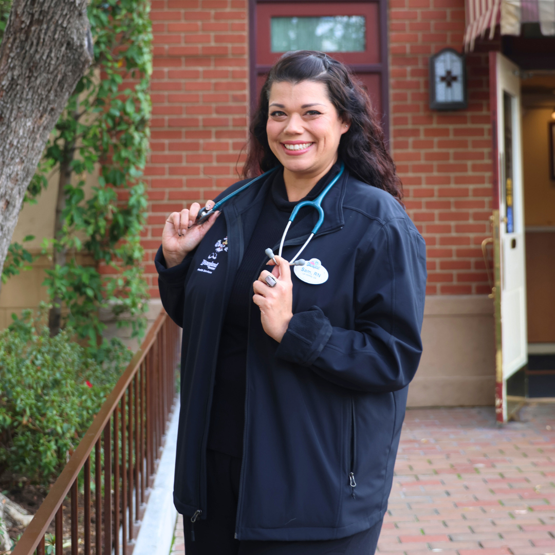 Cast member Samantha poses in front of the Disneyland park First Aid building. 