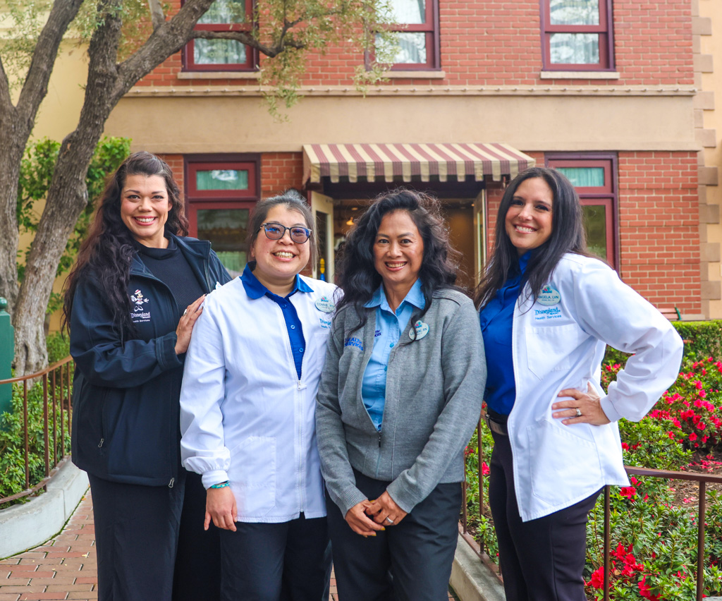 Disneyland Resort Nurses pose in front of Disneyland park First Aid.