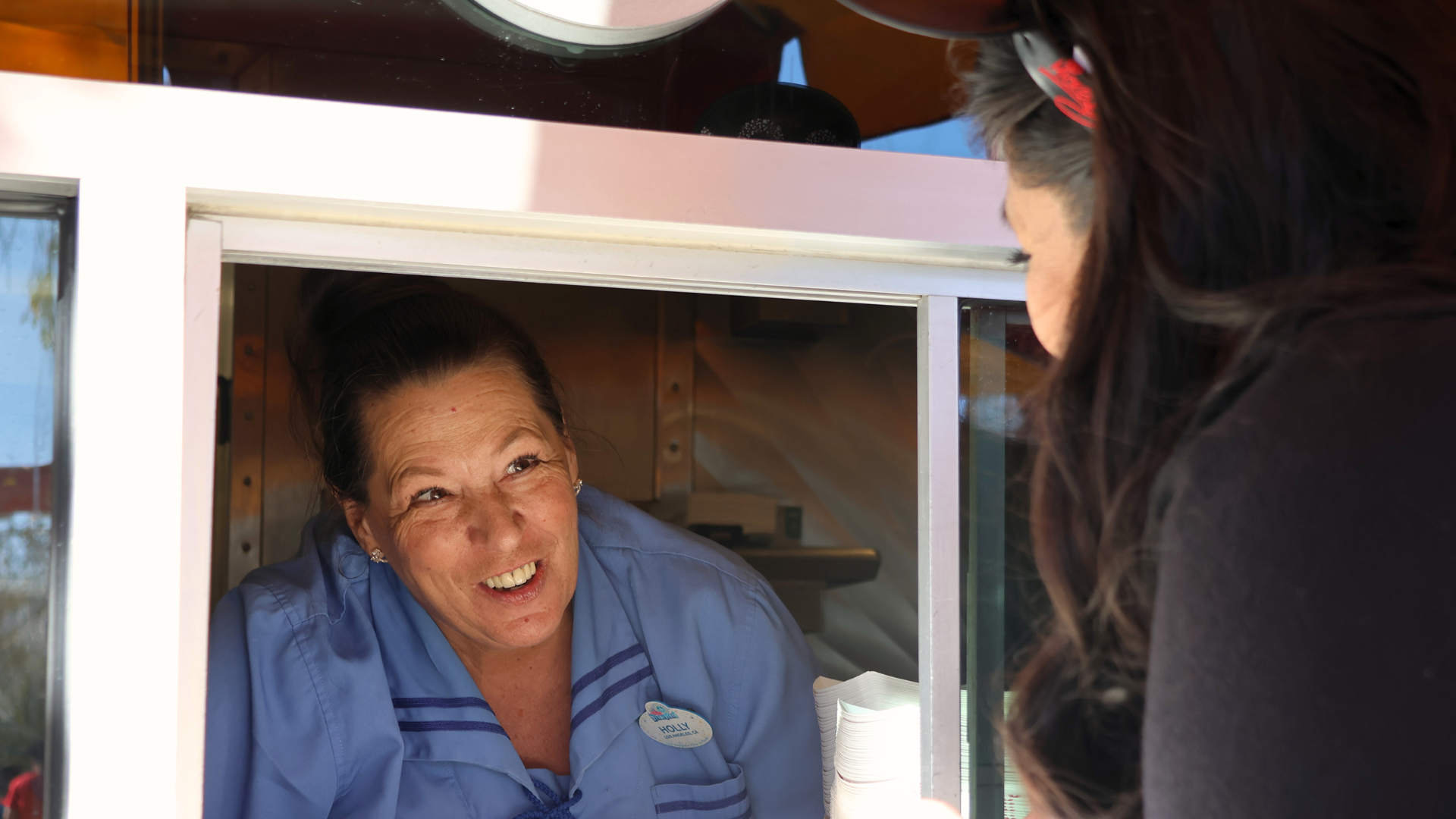 Holly shares a quick smile with a guest picking up their mobile order.