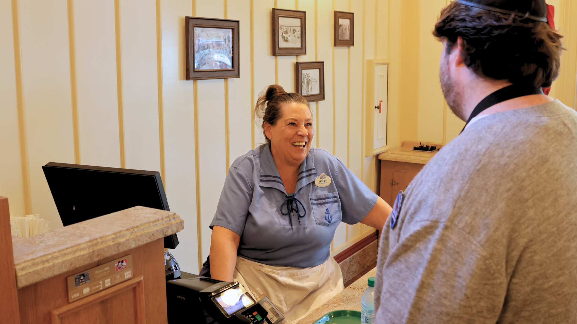 Holly congratulates a guest on their recent graduation as she rings up their order.